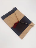 POCHETTE RIGATA NERO ORO CON NAPPINA BORDEAUX
